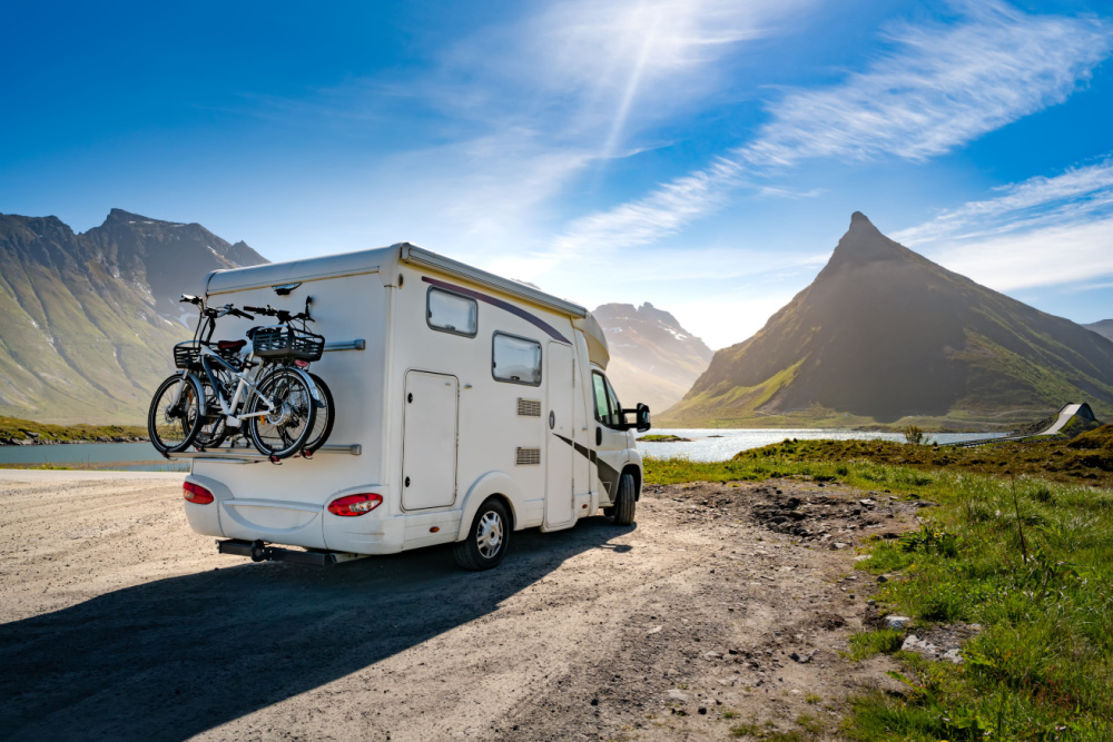 A recreational vehicle parked in a parking lot with a gas station in the background